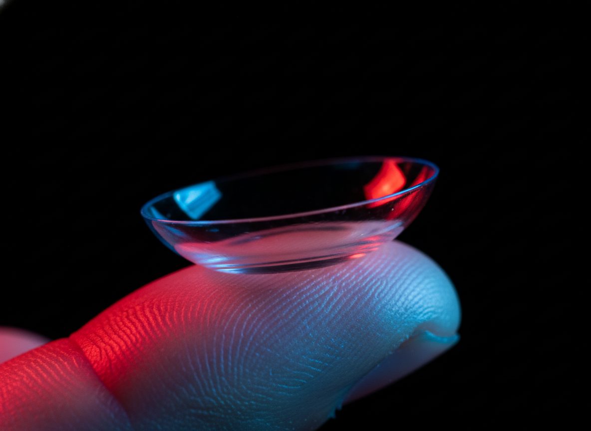 Macro shot of a contact lens lit by a crimson rim light.